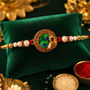 Elegant Rakhi With Peacock Feather Design And Pearl Bead Accents On Red Thread