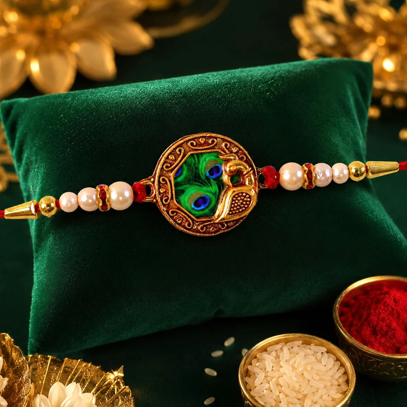 Elegant Rakhi With Peacock Feather Design And Pearl Bead Accents On Red Thread